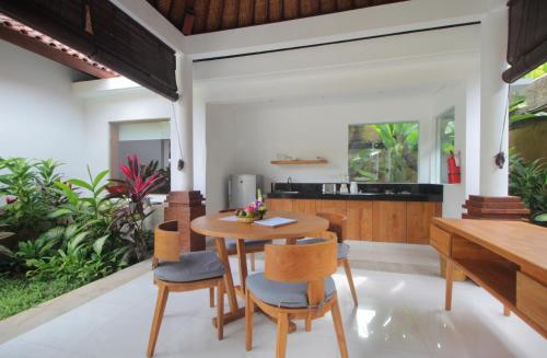 uma cozinha e sala de jantar com uma mesa de madeira e cadeiras em Sagara Villas and Suites Sanur em Sanur