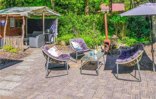 a patio with chairs and a table and an umbrella at T Vosje in Emst
