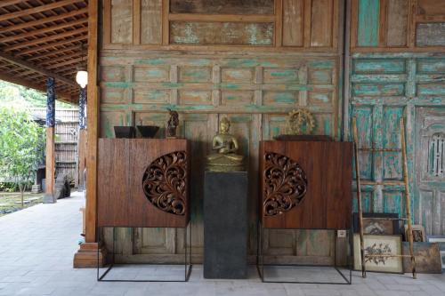 a room with a wooden wall with a statue on it at Villa Indi Yogyakarta in Waluadeg