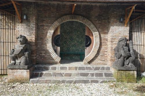 a brick building with two statues in front of a door at Villa Indi Yogyakarta in Waluadeg