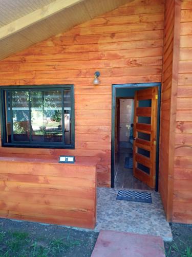 a building with a wooden wall and a door at Cabañas Budi in Panguipulli