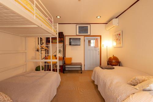 een slaapkamer met 2 bedden en een televisie bij Assi in Yufu