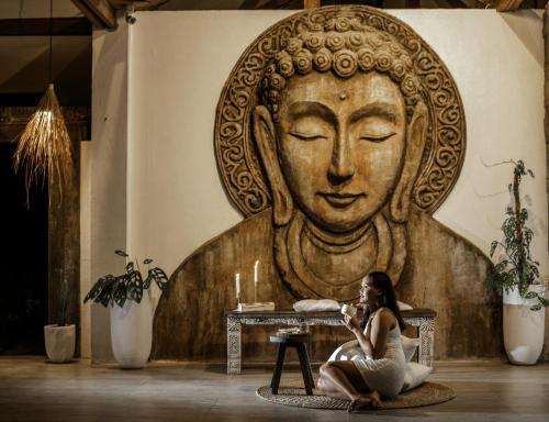 a woman sitting on the floor in front of a large statue at Ocean Vida Beach and Dive Resort in Daanbantayan