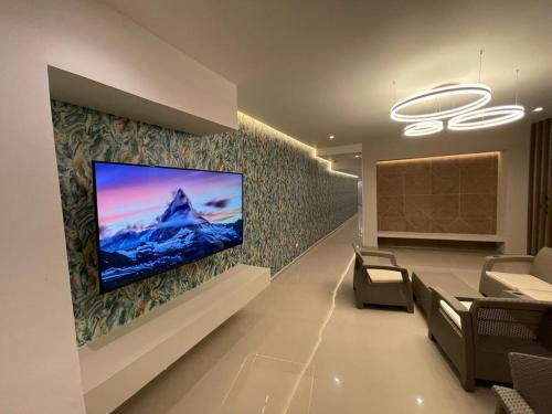 a living room with a tv on a wall at Oasis Hotel in San Andrés