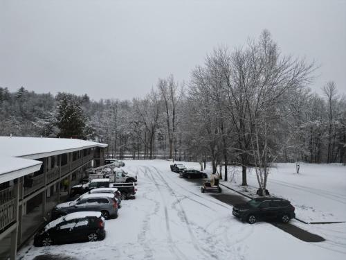 a snow covered street with cars parked in a parking lot at The Putney Inn in Putney