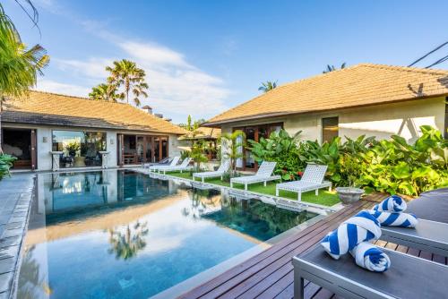 a villa with a swimming pool and a house at The Akasha Luxury Villas in Seminyak