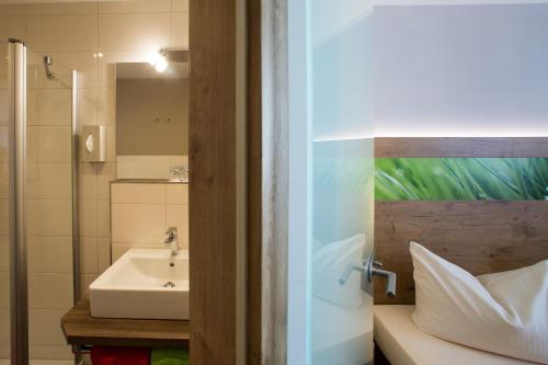 ein Bad mit einem Waschbecken und einer Dusche in der Unterkunft Hotel Bauer garni in Ingolstadt