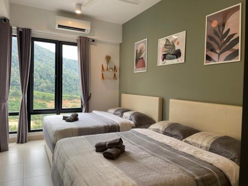 a bedroom with two beds with shoes on them at INS Home at Midhills Genting Highlands Free WiFi in Bentong