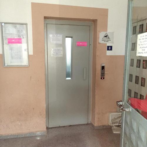a door in a building with a sign on it at Low-Cost City Studio in Mitrovicë