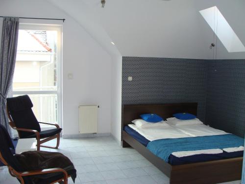 ソポトにあるAqua1000のベッドルーム1室(ベッド1台、椅子、窓付)