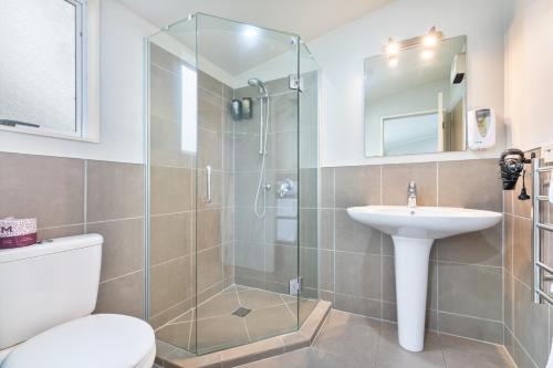 a bathroom with a shower and a sink and a toilet at Northridge Golf Resort in Orewa