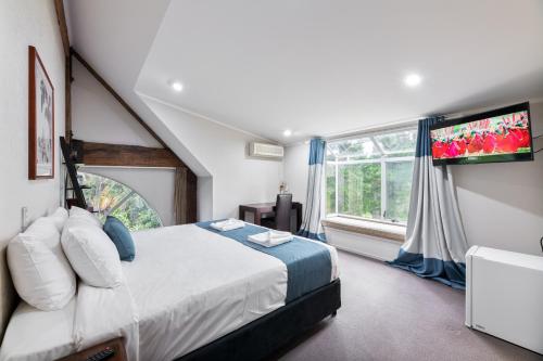 a bedroom with a bed and a large window at Northridge Golf Resort in Orewa