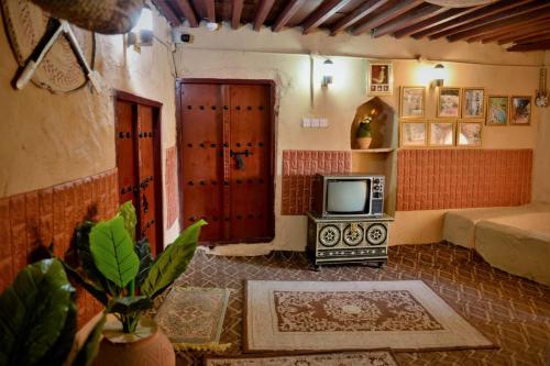 a living room with a tv in a room at Al Misfah Hospitality Inn in Misfāh