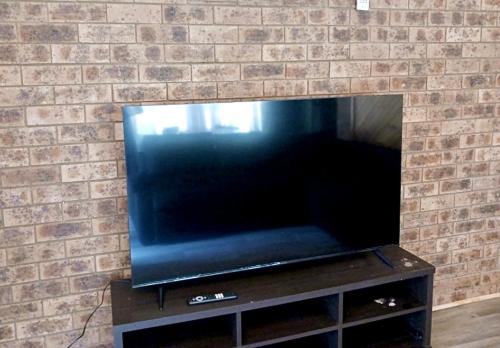 a large flat screen tv in a brick wall at Western Plains Tourist Park - Dubbo in Dubbo