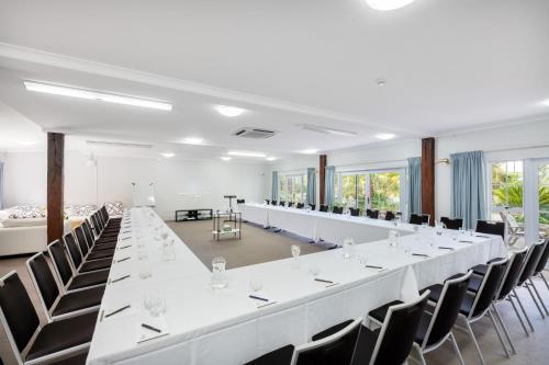 a large white room with a long table and chairs at Northridge Golf Resort in Orewa
