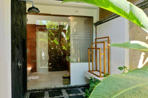a bathroom with a shower and a glass door at Sagara Villas and Suites Sanur by AHM in Sanur