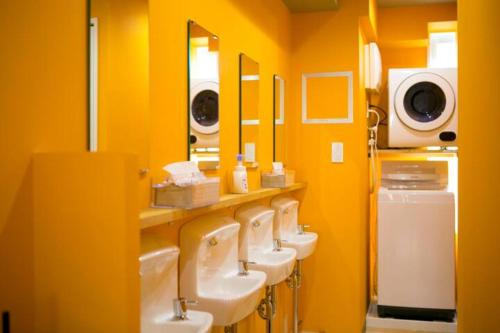 uma casa de banho com uma fila de lavatórios e espelhos em 2023 NEW OPEN Island Japan Hotel & Cafe em Tóquio