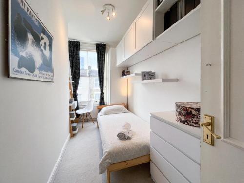 Habitación pequeña con cama y escritorio. en Beautiful 3BD Flat in Archway London, en Londres
