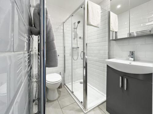 a bathroom with a shower and a toilet and a sink at Beautiful 3BD Flat in Archway London in London