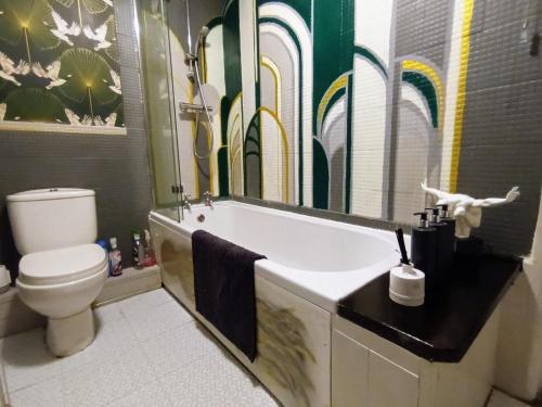 a bathroom with a tub and a toilet and a mirror at Hebden Bridge - House - Sleeps 8 - Pet Friendly in Hebden Bridge