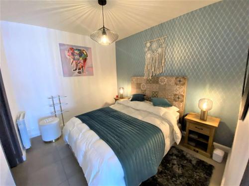 une chambre avec un grand lit avec une couverture bleue dans l'établissement Appartement 3* rénové, 1 chambre, WIFI, à 200m plage de Trégastel, centre, vélos électriques offerts - FR-1-368-229, à Trégastel