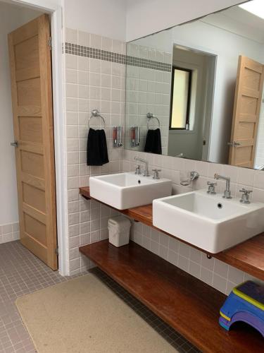 a bathroom with two sinks and a mirror at The Hideaway Jervis Bay in Vincentia