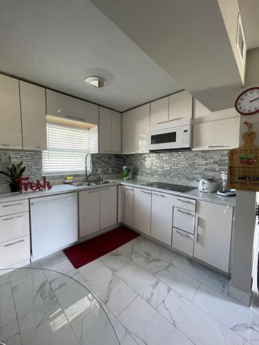 a kitchen with white cabinets and a microwave at 3 miles to Siesta Key #1 Beach in America in Sarasota
