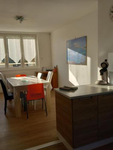 une cuisine et une salle à manger avec une table et des chaises dans l'établissement La Menuiserie, à Myennes