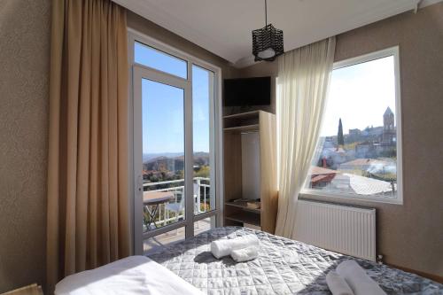 a bedroom with a bed and a large window at Guest House Alazani Valley in Sighnaghi