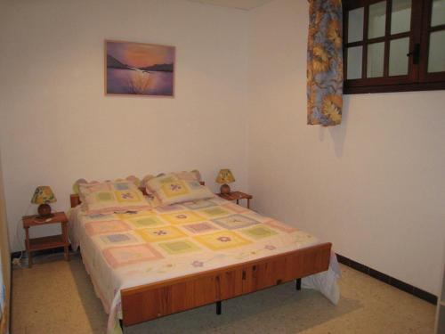 une chambre avec un lit et un tableau au mur dans l'établissement Charmant T3 avec Terrasse et Jardin, Quartier Super Cavalaire, Parking Inclus - FR-1-100-183, à Cavalaire-sur-Mer