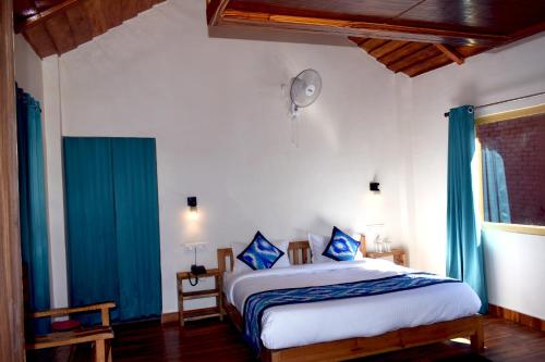 a bedroom with a large bed with blue curtains at LaSerene The Cottage in Nainital