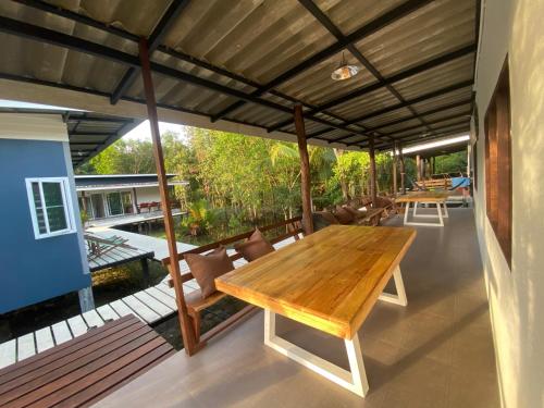 an outdoor dining area with a wooden table and chairs at PD Guesthouse in Ko Kood