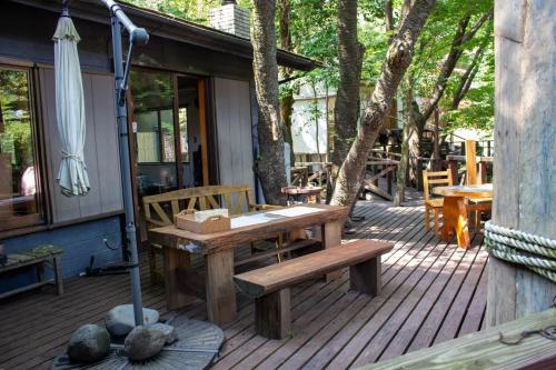 una terraza de madera con mesa de picnic y sombrilla en Glamping Himeshara - Vacation STAY 01948v, en Kirishima