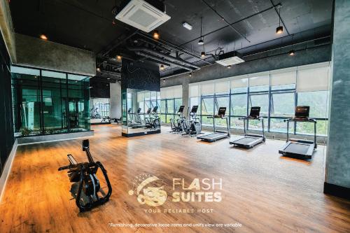 a gym with treadmills and exercise bikes on a wooden floor at Onsen Premium Suites @ Tambun Ipoh in Ipoh