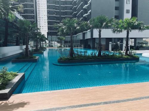 ein großer Swimmingpool mit Palmen auf einem Gebäude in der Unterkunft Maxim 2 bedrooms MRT station Cheras Kuala Lumpur HomeStay in Kuala Lumpur