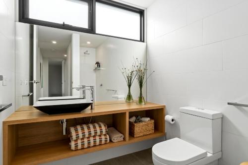 a bathroom with a sink and a toilet at Glassy Point - 360 degree views in Wye River