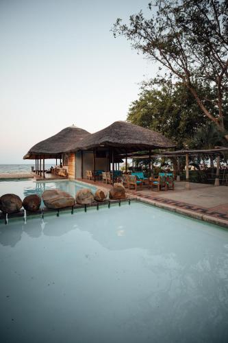 a swimming pool with a house and a resort at The Makokola Retreat in Mponda