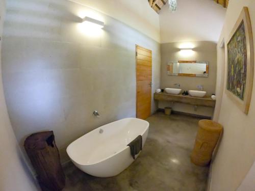 a bathroom with a large tub and a sink at The Makokola Retreat in Mponda