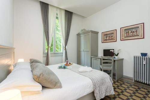sypialnia z dużym białym łóżkiem i biurkiem w obiekcie The Leoncino Hotel w mieście Brescia