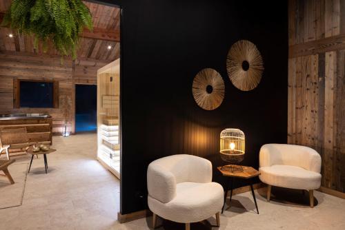 a room with two chairs and a bird cage on a wall at Hôtel et Spa Le Vermont in Le Grand-Bornand