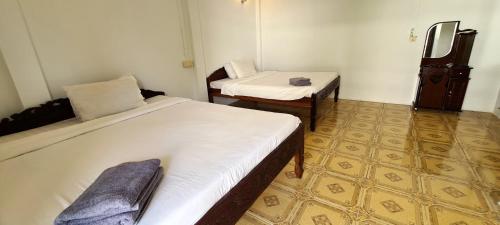 a room with two beds and a chair in it at Khmer House Guesthouse in Kep