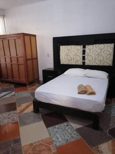 Un dormitorio con una cama con dos zapatos. en Lugar encantador con alberca en Chiapa de Corzo