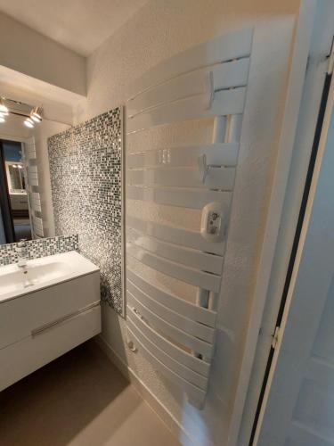 a bathroom with a shower with a sink and a mirror at 40m2 - Ski aux pieds - La Tania - Parking couvert in La Perrière