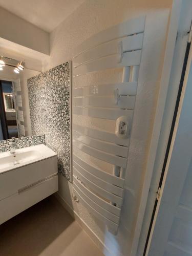 a bathroom with a shower with a sink and a mirror at 40m2 - Ski aux pieds - La Tania - Parking couvert in La Tania