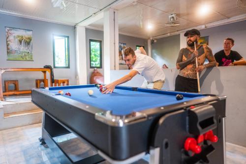 a group of men standing around a pool table at K-Bunk AoNang Center in Ao Nang Beach