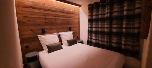 a bedroom with a white bed with two pillows at 40m2 - Ski aux pieds - La Tania - Parking couvert in La Tania