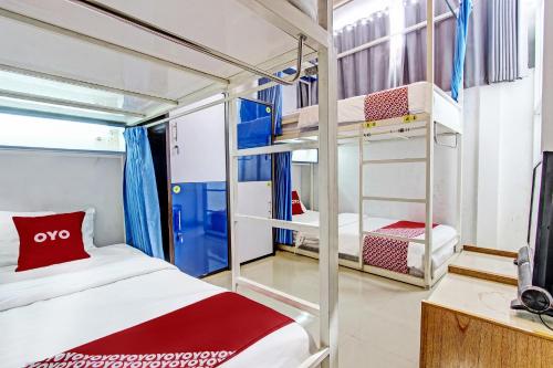 a room with two bunk beds and a television at OYO 91952 Oase Hostel in Yogyakarta