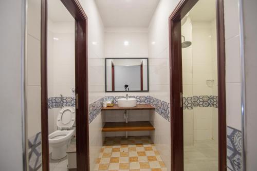 uma casa de banho com um lavatório, um WC e um espelho. em Pooltop Phnom Penh em Phnom Penh