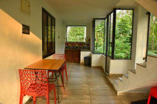 a dining room with a table and chairs and windows at Dhakshina Homestay in Cochin
