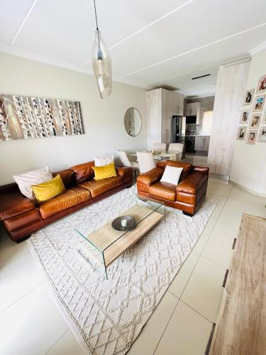 a living room with leather couches and a table at The Escape Haven in Sandton